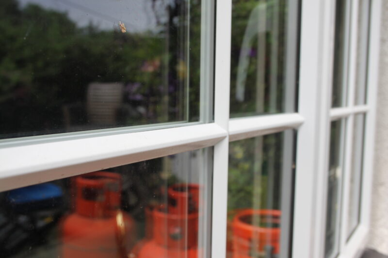 Detail of a window with the reflection of LPG bottles.